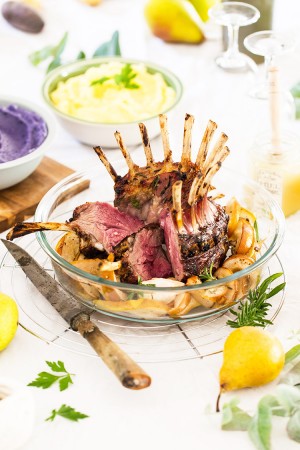 Carré d’agneau en couronne au miel, poires rôties, duo de purées